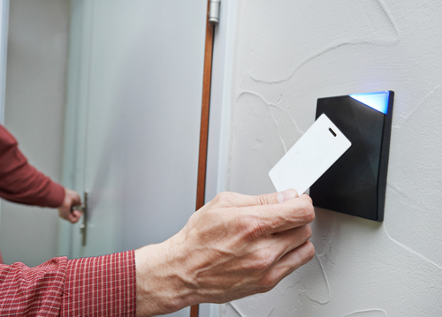 Man using an access control card to unlock a commercial door at a business in Virginia.