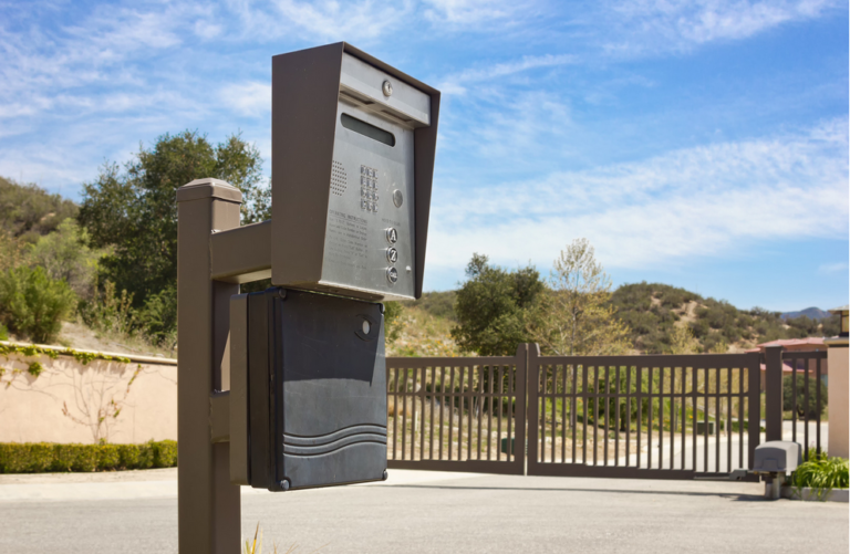 Telephone entry system installed on a pedestal outside the gate of a residential complex.