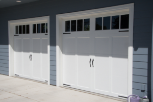 A picture of two residential garage doors installed on a house with blue siding in Washington DC