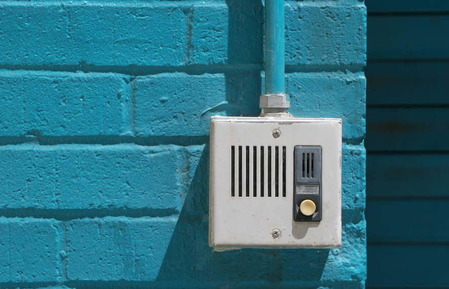 Image of an analog voice only intercom system mounted on a conduit outside a building in Washington DC.